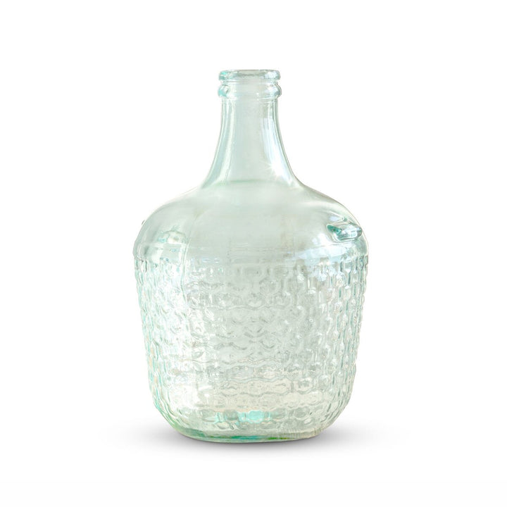 Clear glass bottle with textured surface on a white background