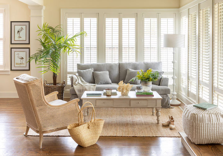 Living room with gray sofa, wicker chair, and decorative elements.