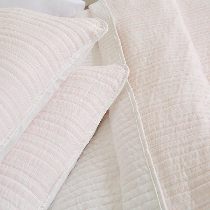 Close-up of a textured beige quilt and pillow