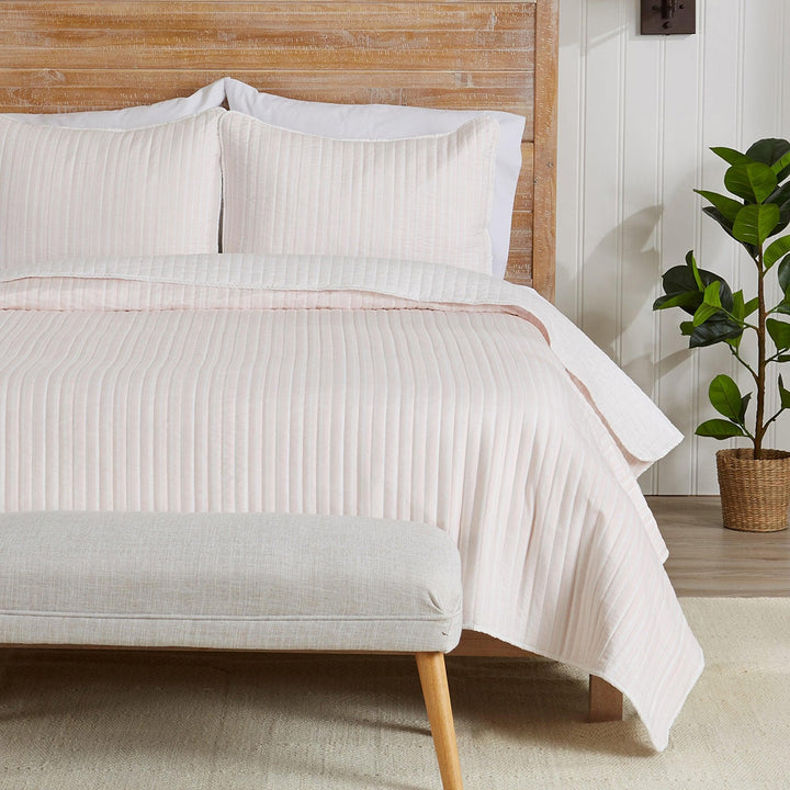 Neatly made bed with striped bedding in a bedroom setting
