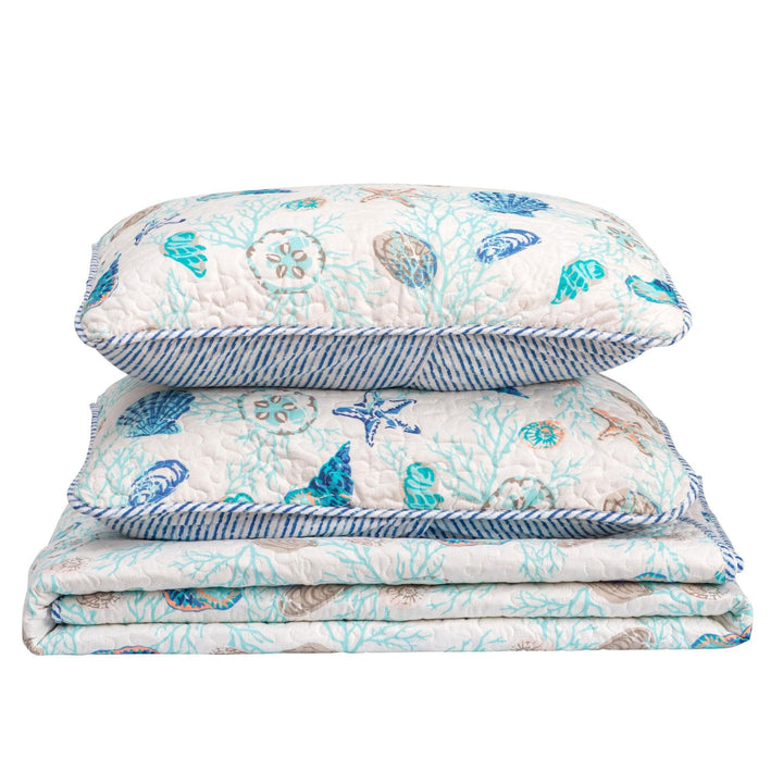 Bedding set stack of seashell-patterned pillows on a white background