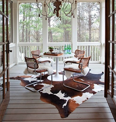 Brazilian tri color cowhide rug on porch- The Coastal Compass Home Decor