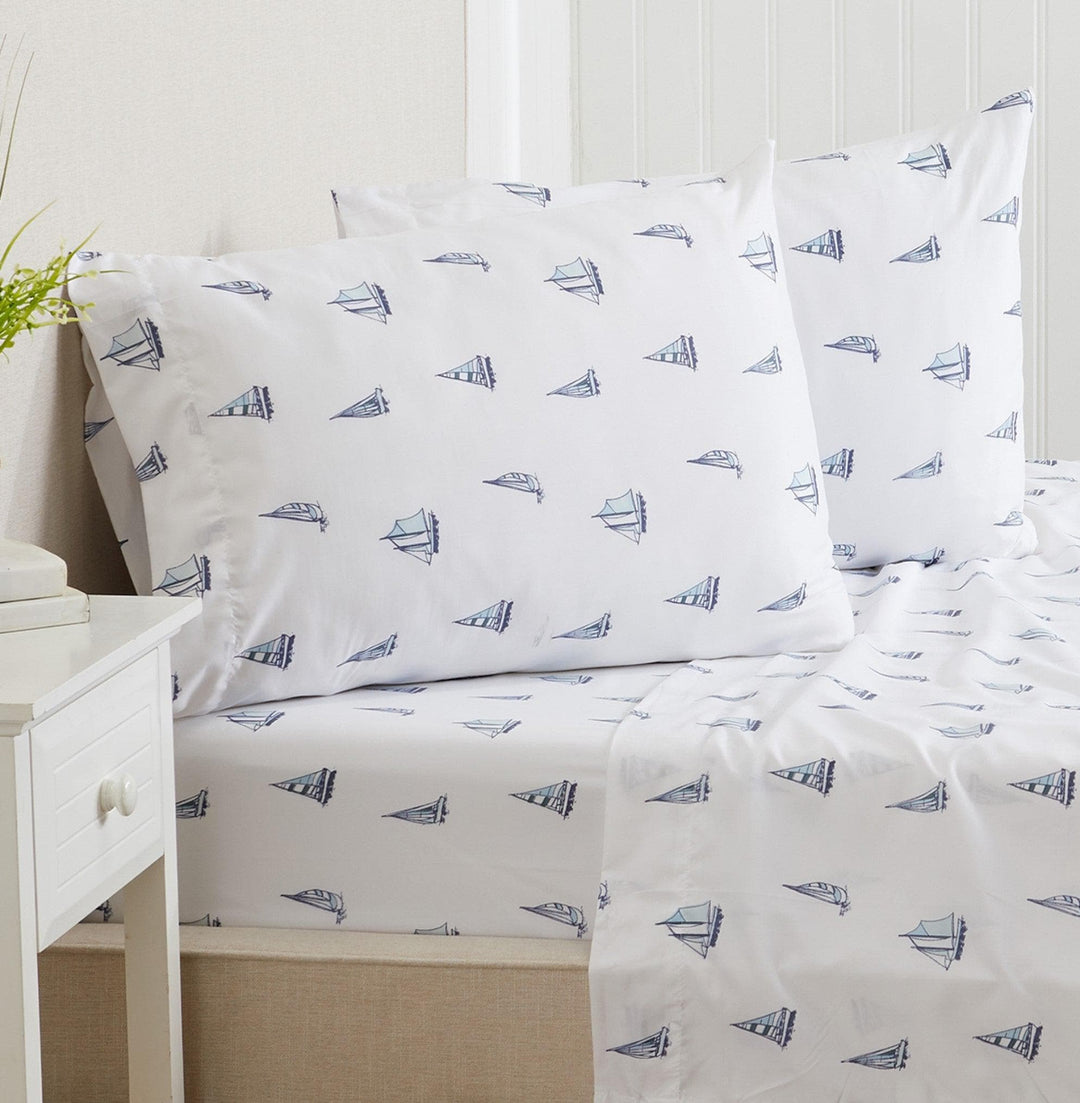 Sheet set with sailboat pattern on a bed in a bedroom setting