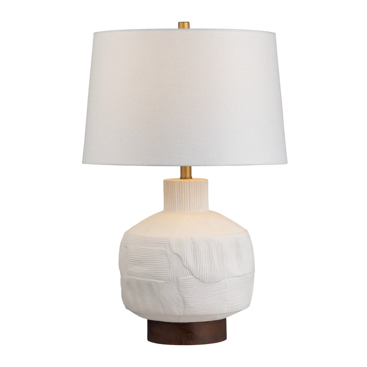 Alora Ceramic Table Lamp with white textured base, walnut wood accent, gold details and white shade illuminated with warm glow 