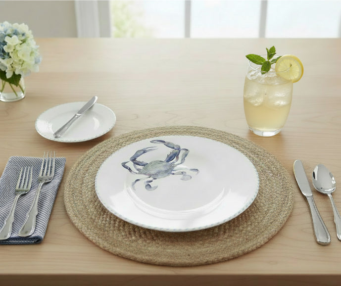 Dining table setting with a crab-themed plate, silverware, and a glass of lemonade.