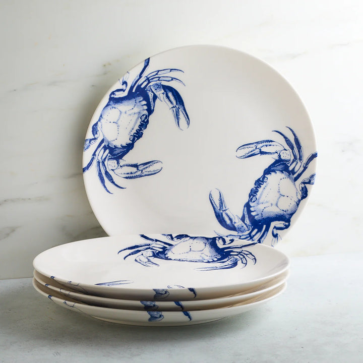 Set of white plates with blue crab designs on a light background