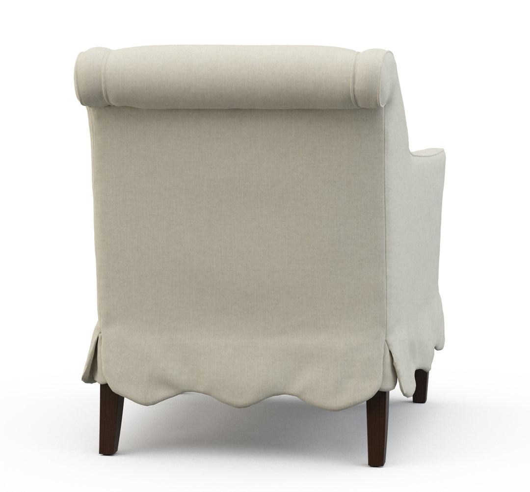 Beige armchair with scalloped edge on a white background. Coastal Compass Home Decor