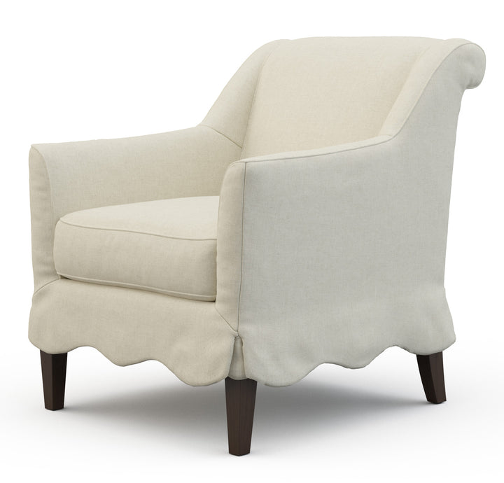 Beige armchair with scalloped edges and wood legs. Coastal Compass Home Decor