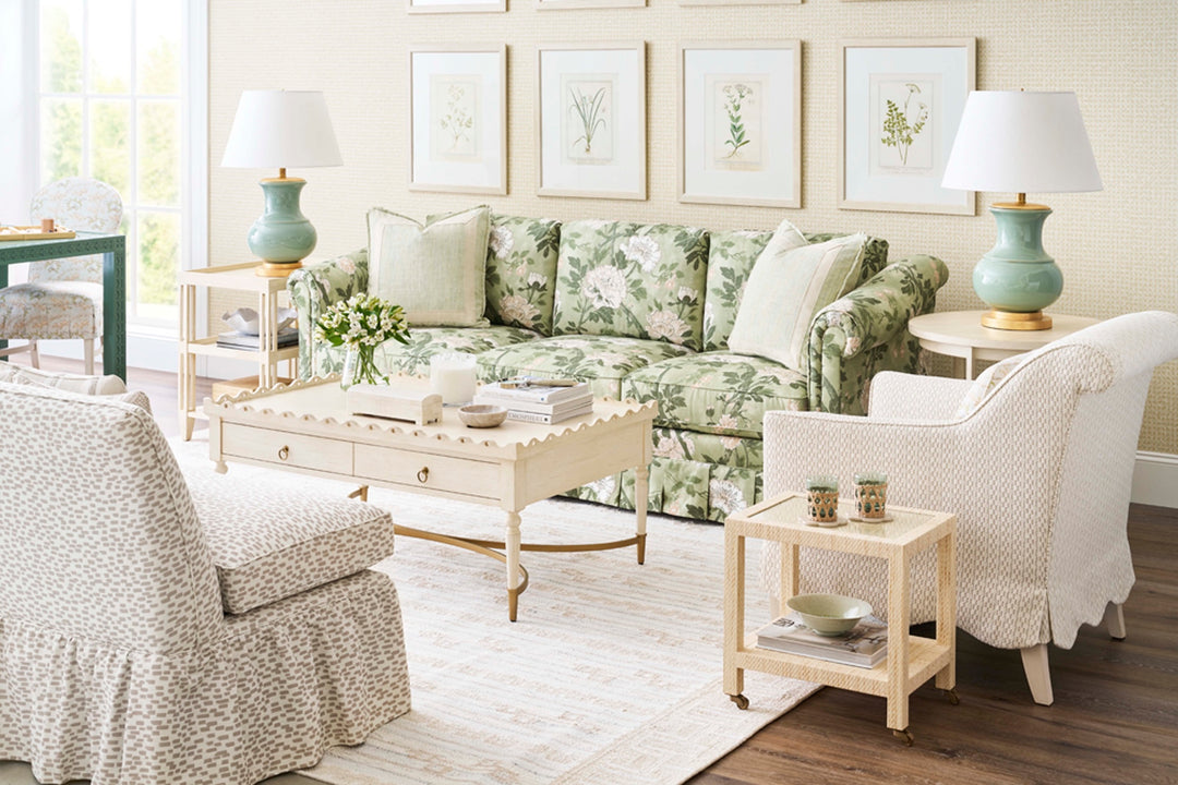 Living room with floral-patterned sofa, armchairs, and decorative items. Coastal Compass