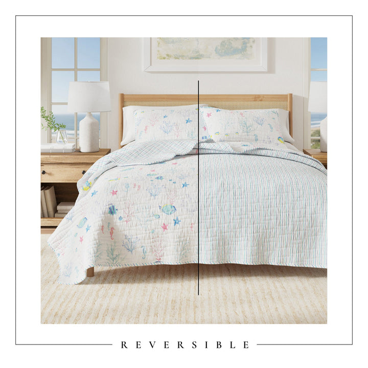 Bed with reversible comforter showing sea creatures and striped patterns in a bedroom setting.