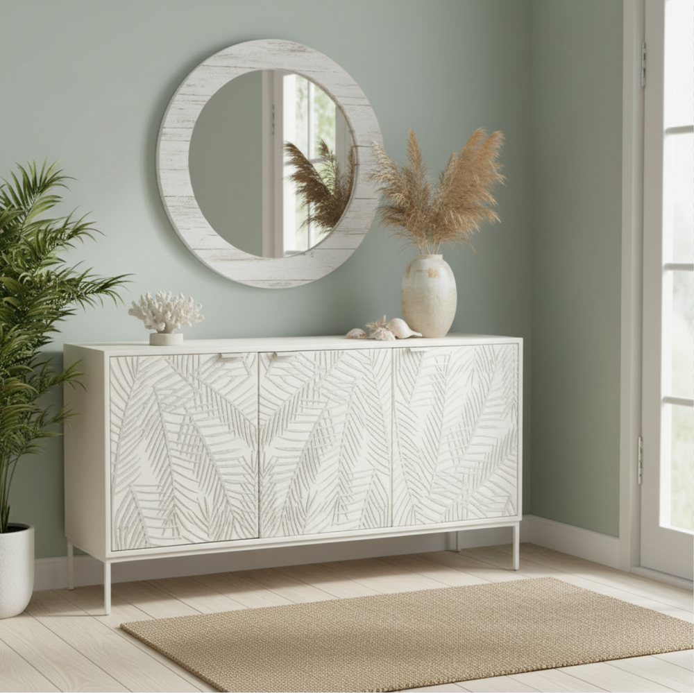 White textured fern sideboard in entryway with round mirror above and vase flowers
