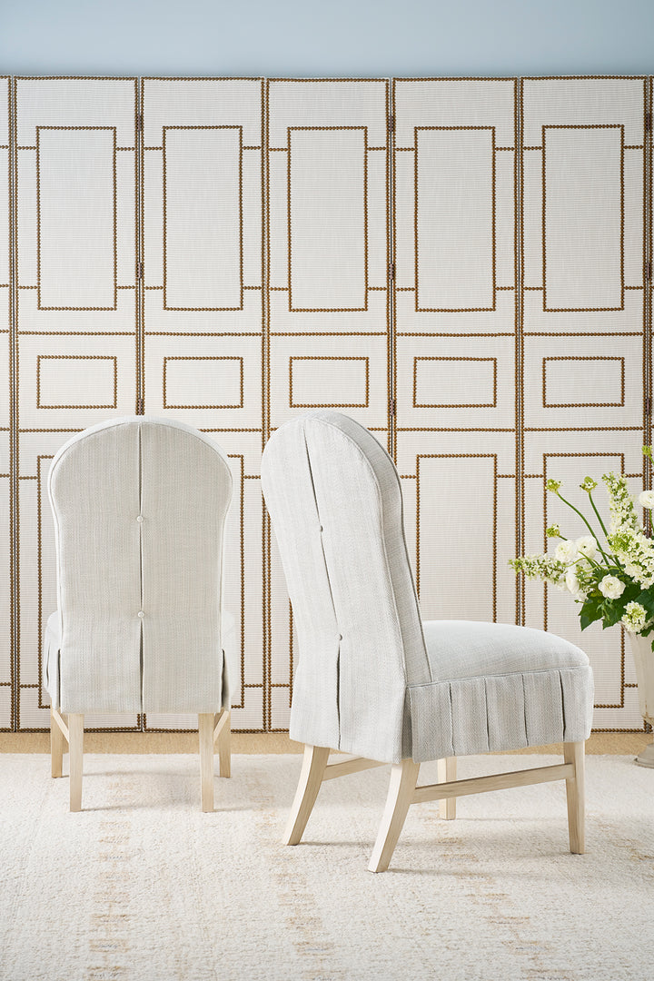 Two upholstered chairs in a room with a decorative wall panel.