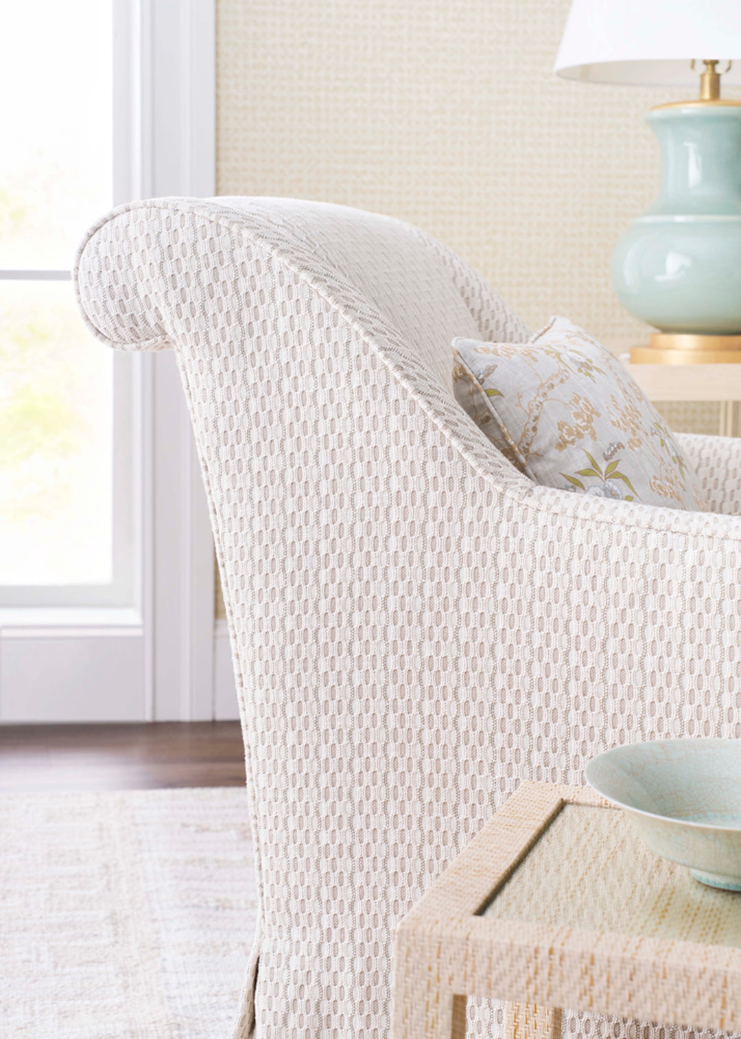 White textured armchair with a decorative pillow. Coastal Compass Home Decor