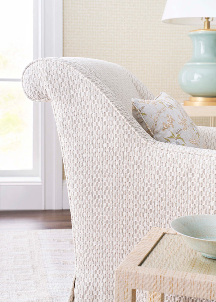 White textured armchair with a decorative pillow. Coastal Compass Home Decor