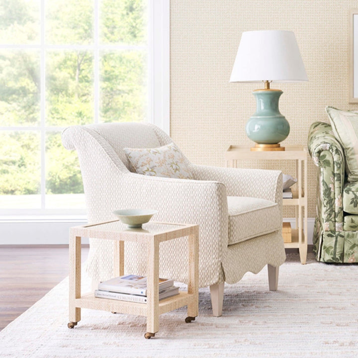 White armchair with a floral-patterned pillow in a bright living room. Coastal Compass Home Decor