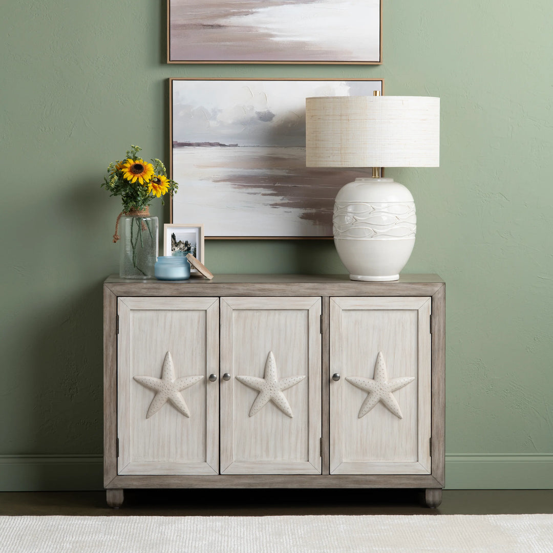 Cabinet with starfish designs against a green wall with framed artwork