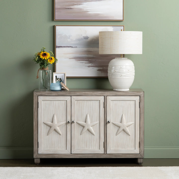 Cabinet with starfish designs against a green wall with framed artwork