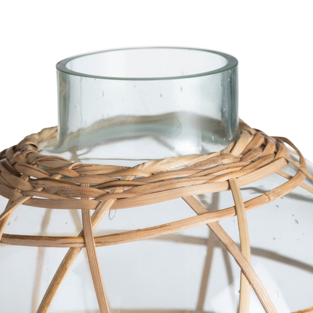 Glass container on a woven wooden stand against a white background