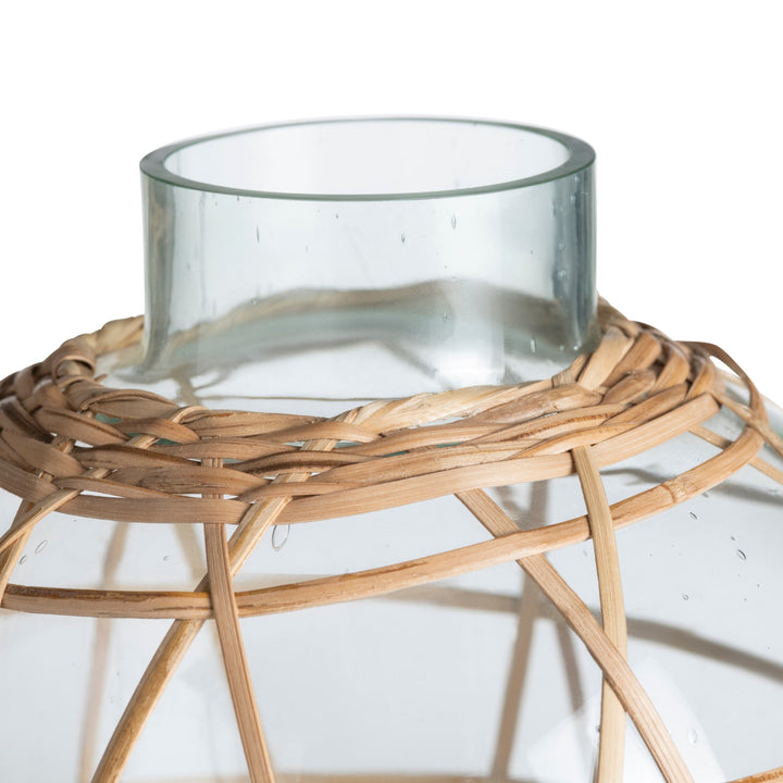 Glass container on a woven wooden stand against a white background