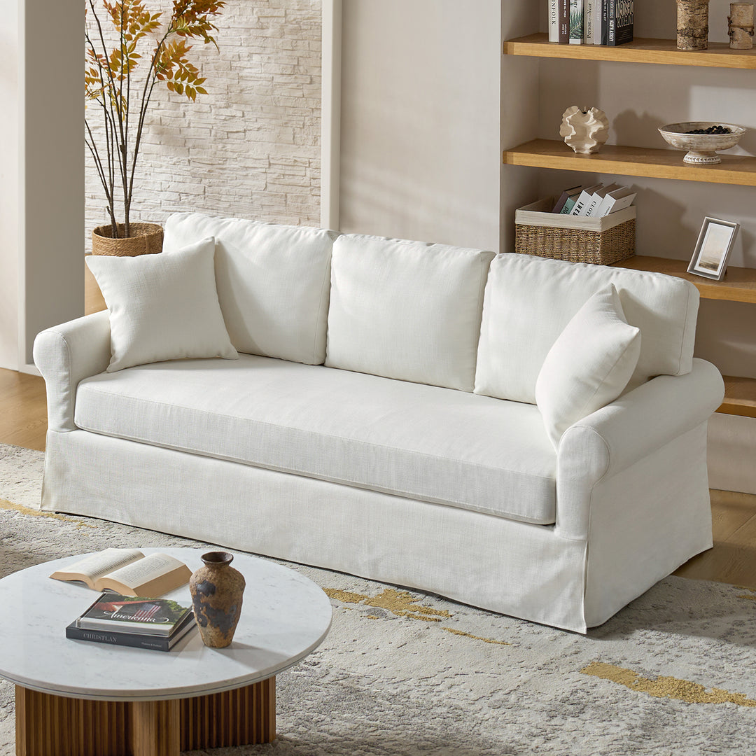 White linen slipcovered sofa in coastal living room with neutral decor and wood accents - Whitehaven sofa
