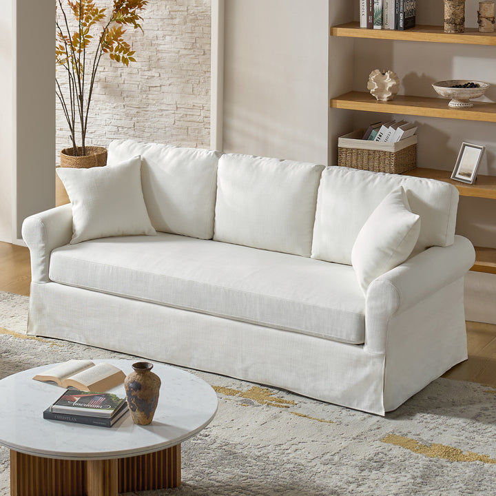 White linen slipcovered sofa in coastal living room with neutral decor and wood accents - Whitehaven sofa