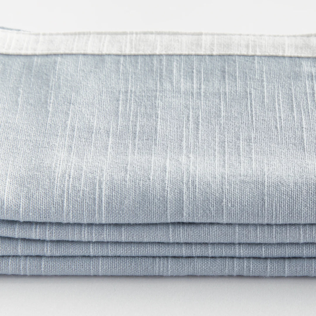 Stack of light blue napkins on a white background. Coastal Compass