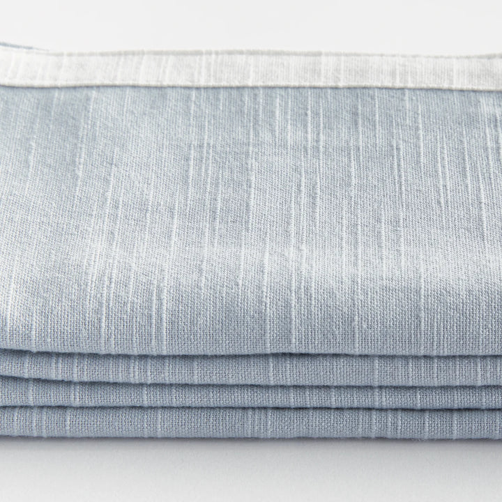 Stack of light blue napkins on a white background. Coastal Compass
