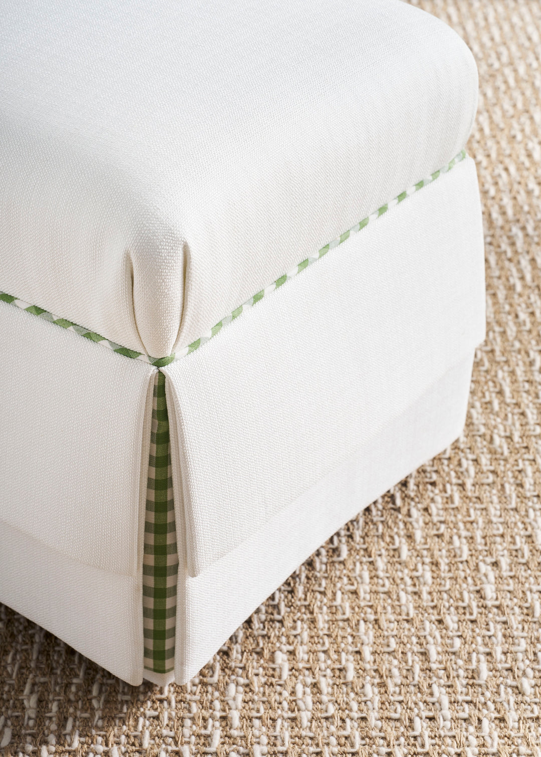White cushion with green trim on a textured surface
