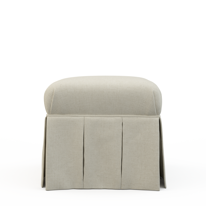 Light gray upholstered ottoman with pleated skirt on a white background