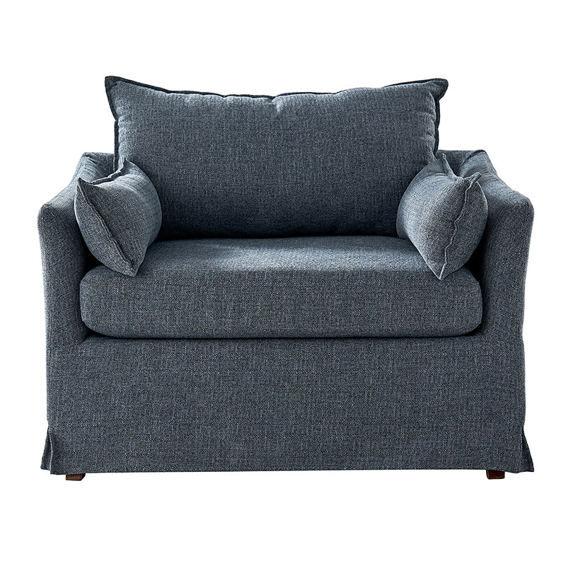 Blue slipcovered lounge chair with wood legs and relaxed coastal design
