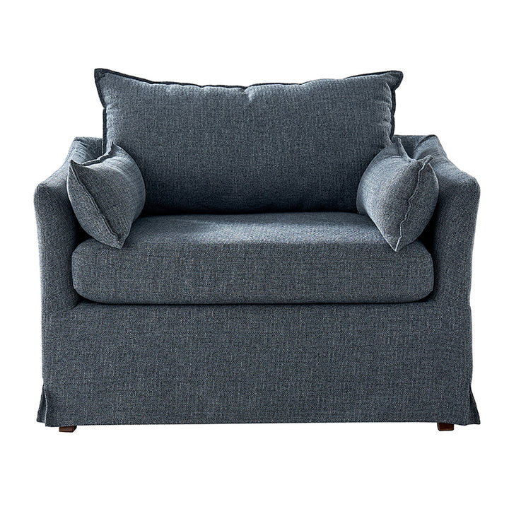 Blue slipcovered lounge chair with wood legs and relaxed coastal design