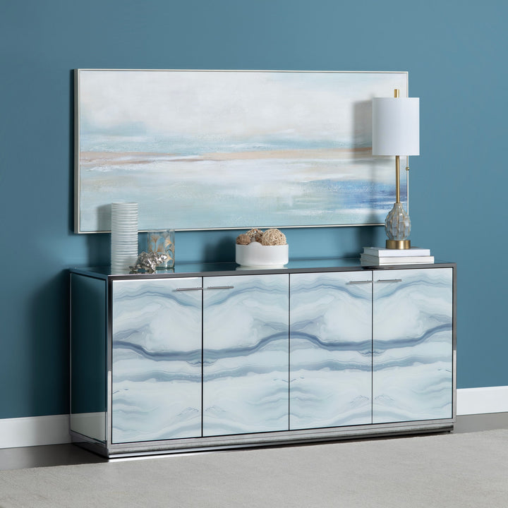 Modern sideboard with abstract art and decorative items against a blue wall.