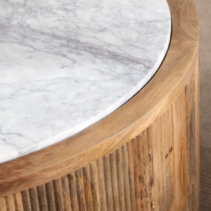 Round wooden table with marble top on a neutral background