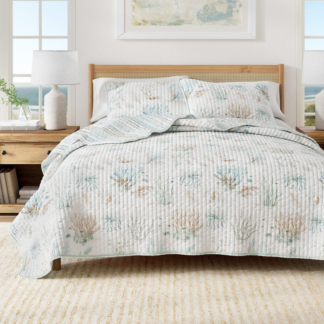 Santa Barbara quilt set featuring pastel ocean motifs and channel stitching styled in an airy coastal bedroom