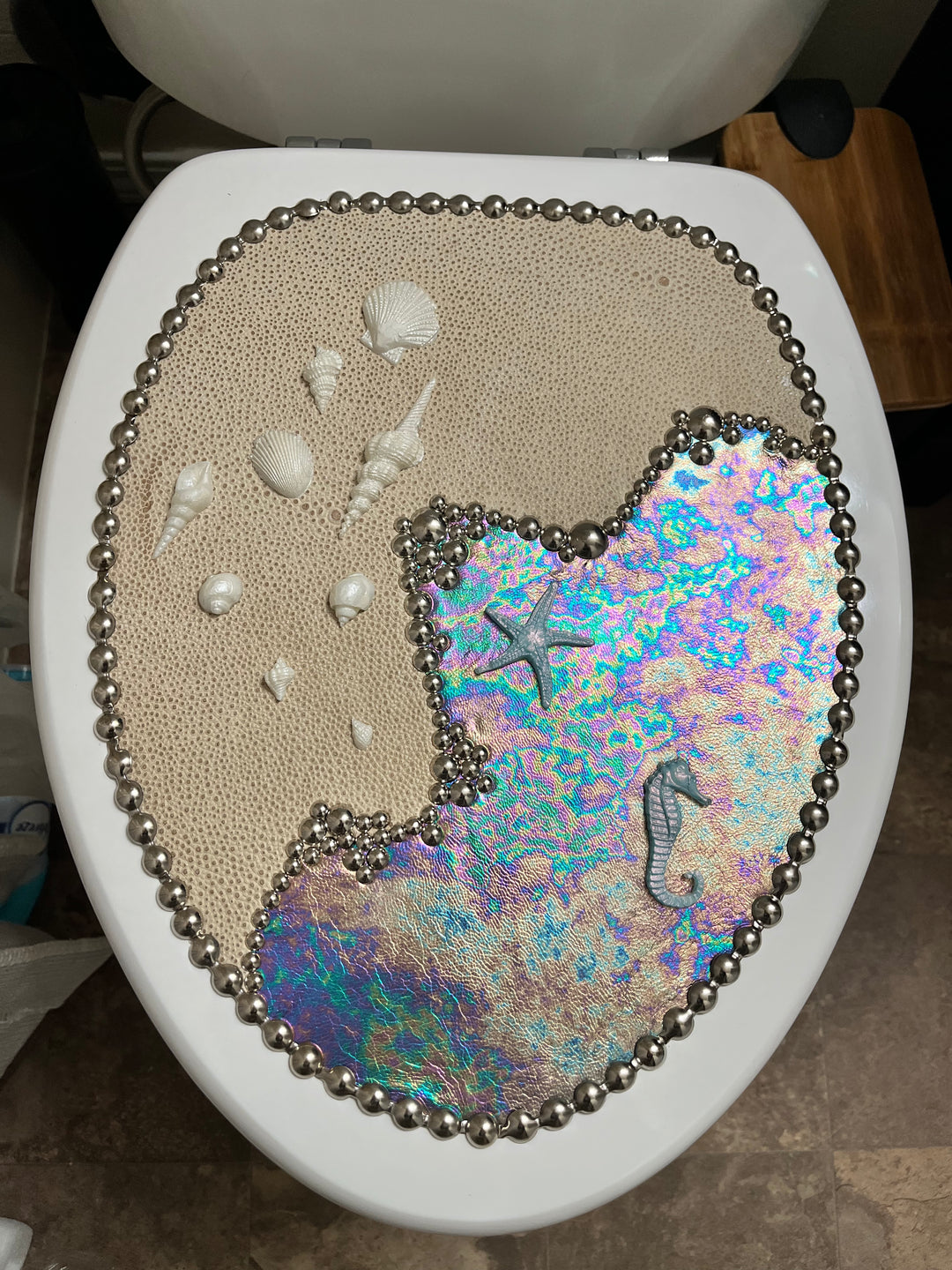 Decorative Sea & Shore toilet seat with seashells, starfish, and a colorful mermaid design.