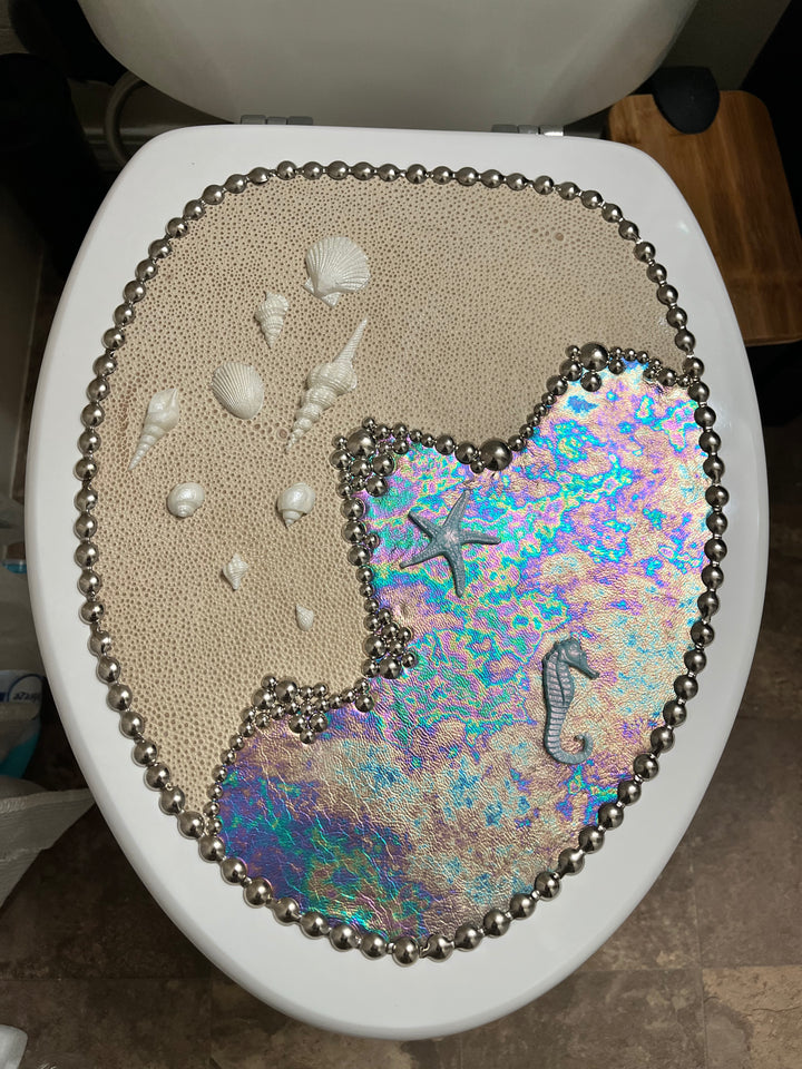 Decorative Sea & Shore toilet seat with seashells, starfish, and a colorful mermaid design.