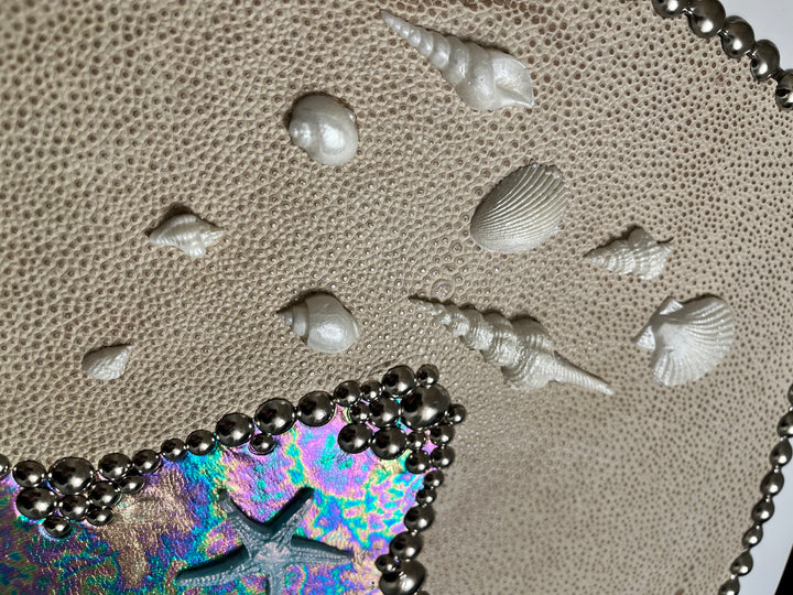 sea and shore decorative toilet seat detail of Seashells and a colorful mermaid tail on a leather