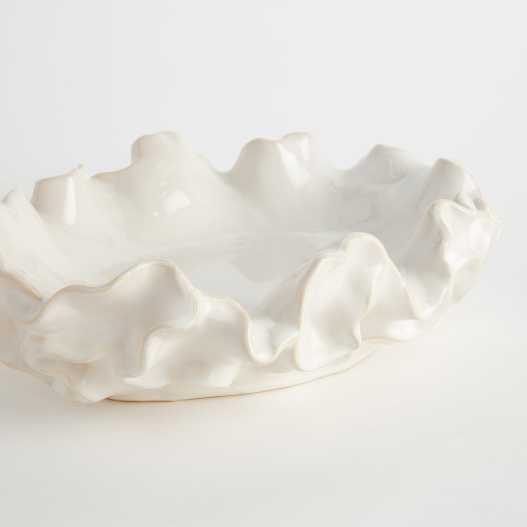 White ceramic bowl with wavy edge on a light gray background