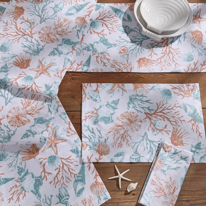 Seaside Treasures coastal table linens featuring coral, seashell, and starfish print with matching placemats, napkins, and table runner.
