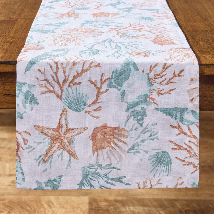 Seaside Treasures coastal table runner with aqua seashells, coral branches, and starfish on a white background.