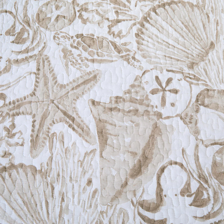 Shoreline Treasures Quilt Pattern of seashells, starfish, and coral on a textured beige background