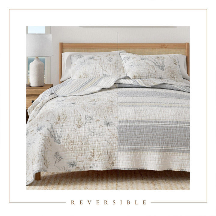 Reversible Shoreline Meadows quilt set on a bed with a wooden headboard and nightstand.