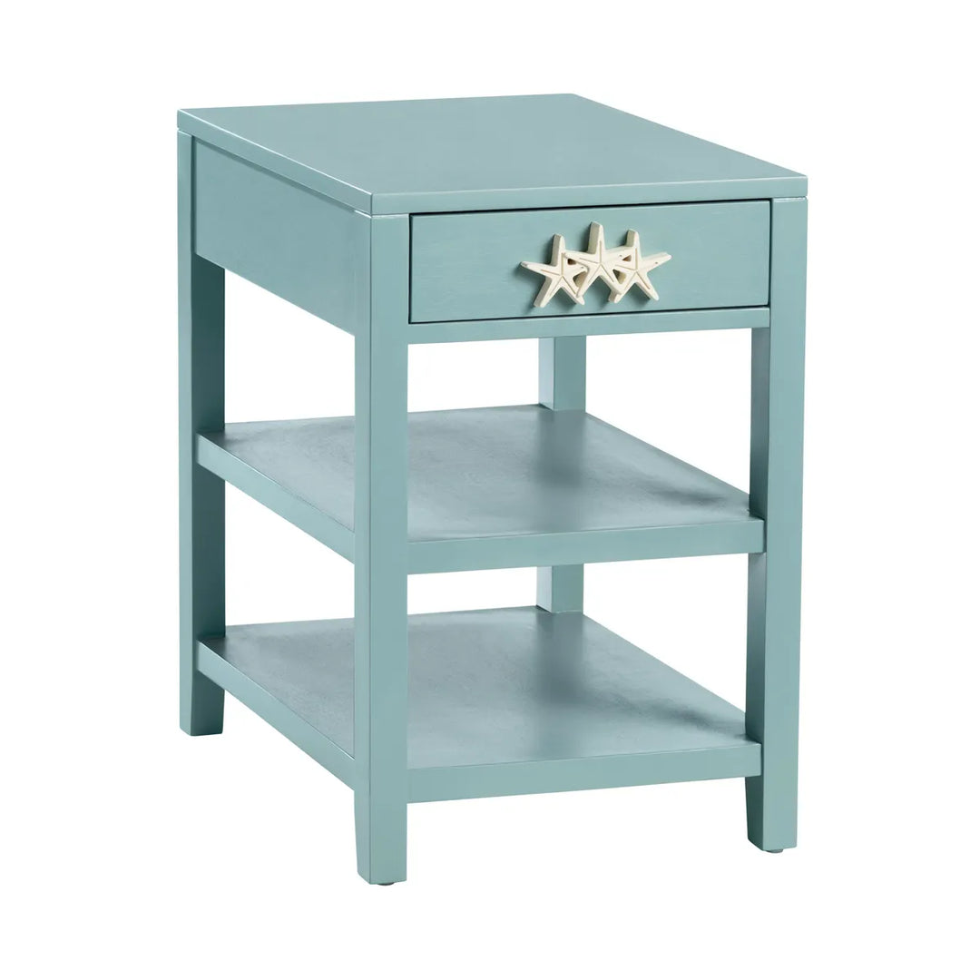 Light blue side table with a starfish decoration on a white background. Features one drawer and 2 shelves with Clean, four-post silhouette.