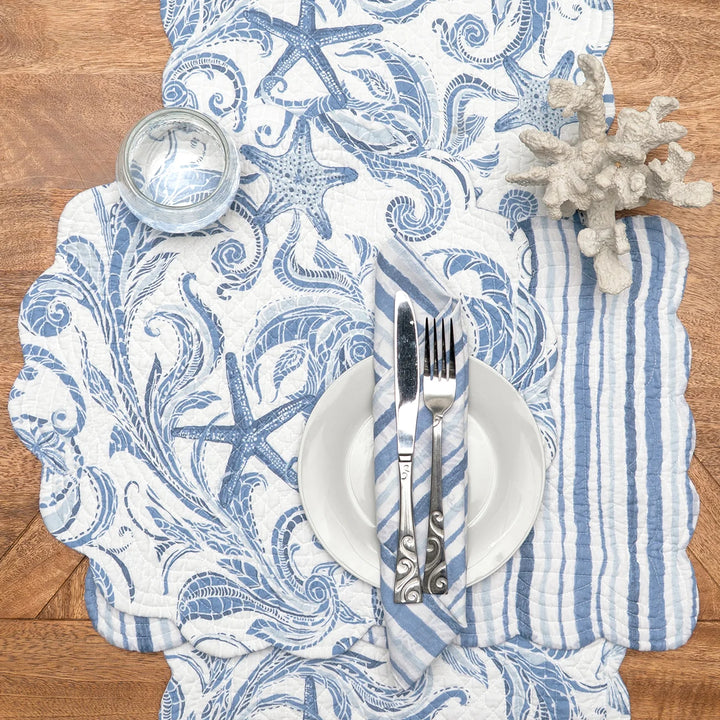 Nautical-themed table linens with starfish design on a wooden table.