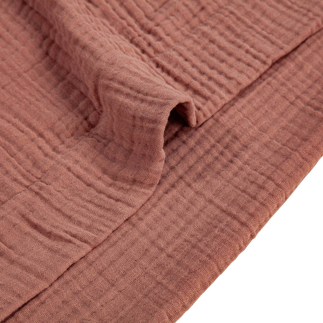 Close-up of textured voile cotton duvet fabric in Clay with a white background