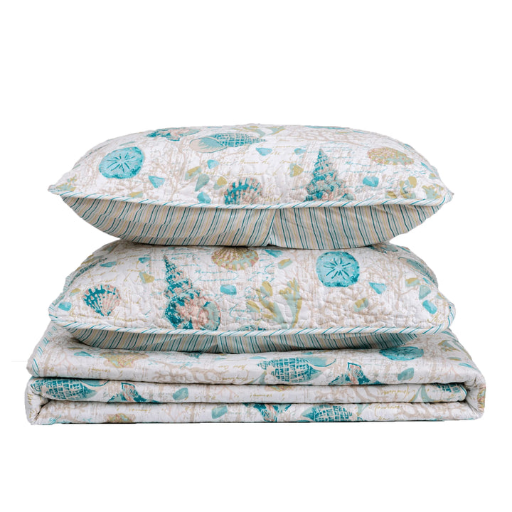 West Sands Seashell Quilt Set with 1 quilt and 2 pillows with matching shams folded in a stack on white background