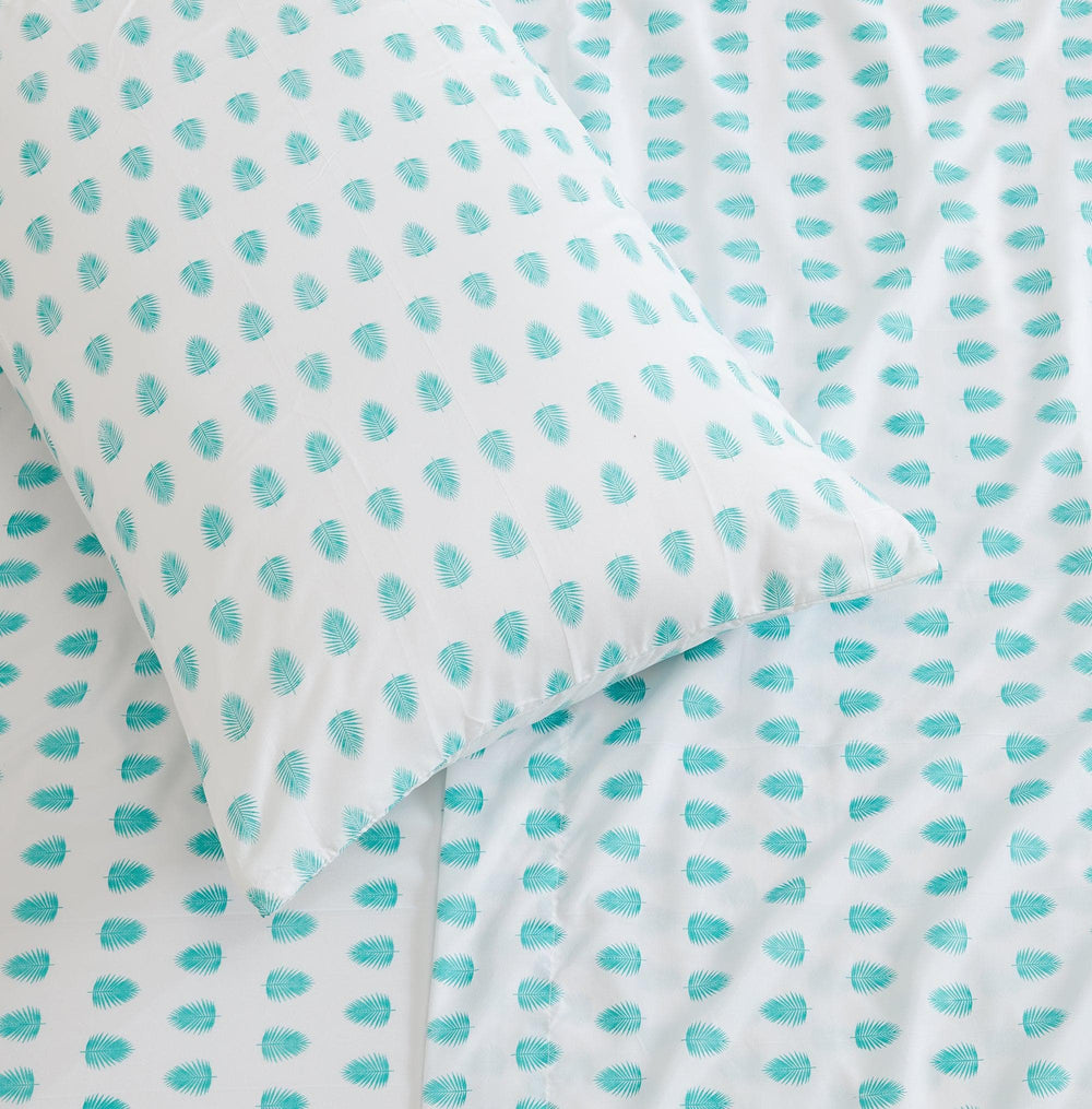 Fabric with turquoise tropical leaf pattern on a white background