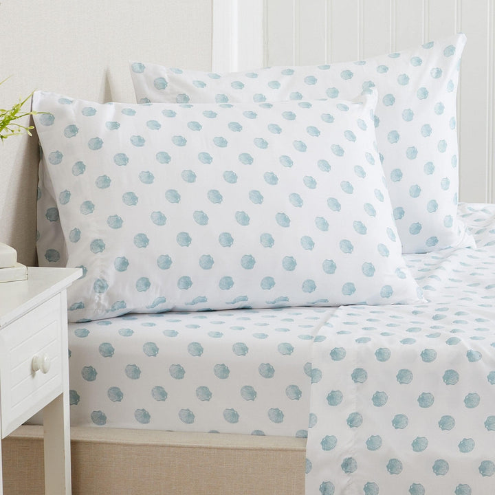 seashell sheet set on a bed with a white nightstand.