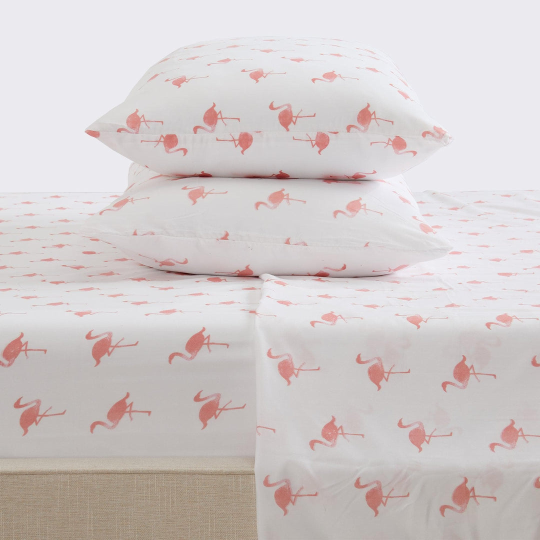 Flamingo-patterned bed sheets and pillows on a white background