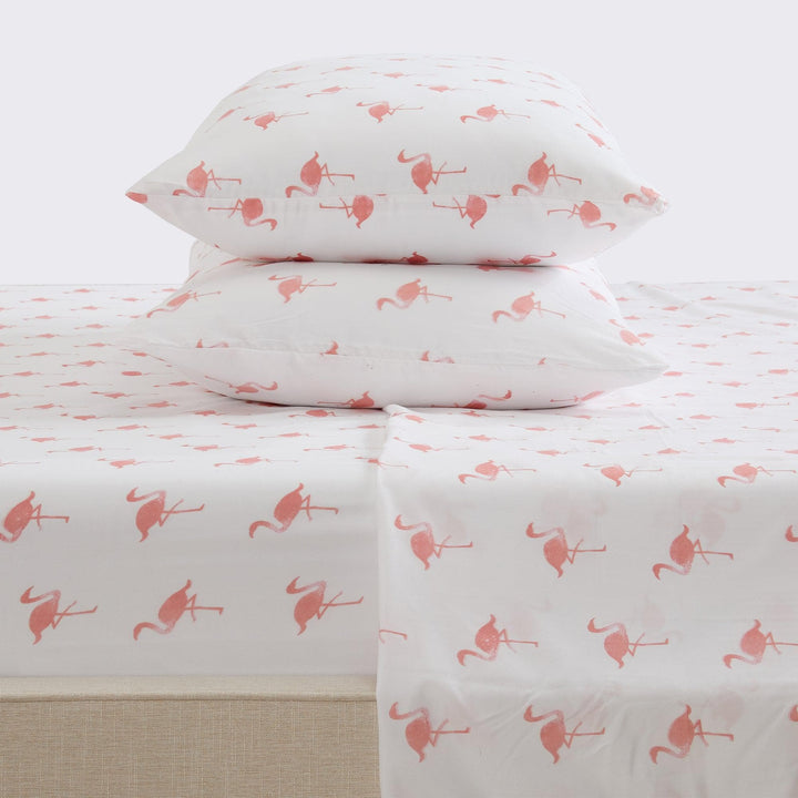 Flamingo-patterned bed sheets and pillows on a white background